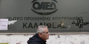 Ενας άνδρας περνά μπροστά από το κέντρο προώθησης της απασχόλησης του ΟΑΕΔ, στην περιοχή της Καλλιθέας