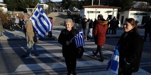 Ανθρωποι στη διάβαση με ελληνικές σημαίες στα χέρια