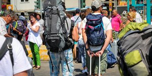 Εκδρομείς στο λιμάνι με σακίδια και καπέλα