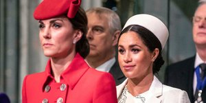 Η Κέιτ Μίντλετον με κόκκινο παλτό και η Μέγκαν με λευκό παλτό