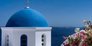 Εκκλησια με τρούλο και λουλουδια στη θαλασσα