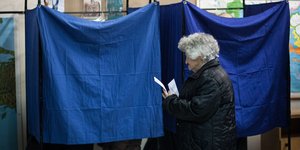 Στιγμιότυπο από τις εκλογές του 2015. Μια ηλικιωμένη πλησιάζει στο παραβάν για να ψηφίσει.