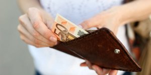 Γυναίκα κρατά πορτοφόλι με λεφτά