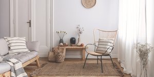 Σαλόνι με έπιπλα από ξύλο και ρατάν, κουρτίνες, ριχτάρια, βάζα με λουλούδια