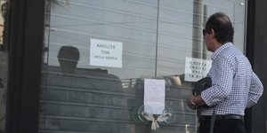 Εργαζόμενος έξω από επιχείρηση που κατέβασε ρολά