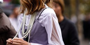 Γυναίκα με πουκάμισο και κολιέ από πέρλες