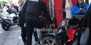 Αστυνομικοί μιλούν σε γυναίκα καθισμένη στο πεζοδρόμιο