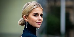 Γυναίκα με τοπ με ανοιχτή πλάτη, ριγέ παντελόνα, ροζ τσάντα 