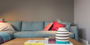 Ένας καναπές, ένα τραπέζι με δίσκο και βιβλία σε ένα σαλόνι