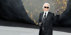 Ο Καρλ Λάγκερφελντ χαιρετά προς τον φακό φορώντας γυαλιά ηλίου