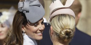 Η Κέιτ Μίντλετον με καπέλο και σκουλαρίκια χαμογελά 