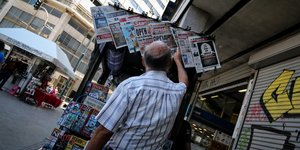 Ανδρας διαβάζει εφημερίδες σε κιόσκι