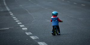 Παιδί με κράνος πάνω σε ποδήλατο, σε άδειο δρόμο