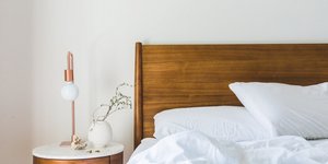 Δωμάτιο ξενοδοχείου με κρεβάτι, κομοδίνο, λευκά σεντόνια