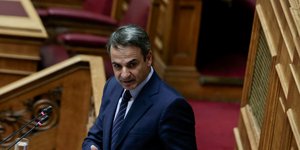 Κυριάκος Μητσοτάκης στη Βουλή με κόκκινο φόντο