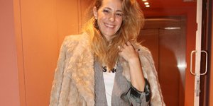 Η Νατάσα Μποφίλιου χαμογελάει κρατώντας μεγάλη τσάντα και φορώντας τζιν με σακάκι