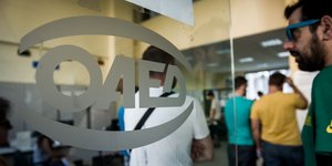 Ενας άνεργος περιμένει τη σειρά του, έξω από τα γραφεία του ΟΑΕΔ στην περιοχή της Καλλιθέας