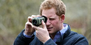 Ο πρίγκιπας Χάρι κρατώντας μια φωτογραφική μηχανή
