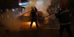 Πυροσβέστης σβήνει φωτιά σε αυτοκίνητο