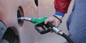 Υπάλληλος σε πρατήριο υγρών καυσίμων γεμίζει με βενζίνη το ρεζερβουάρ ΙΧ