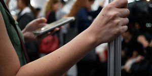 Γυναικείο χέρι αγγίζει χειρολαβή του μετρό 