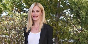 Η Ζέτα Μακρυπούλια με μαύρο κοστούμι και λευκά αθλητικά παπούτσια