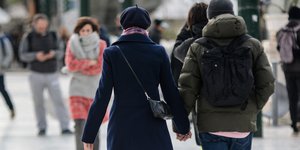 Ενα ζευγάρι περπατά χέρι - χέρι στους δρόμους της Αθήνας