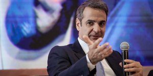 Κυριάκος Μητσοτάκης με μικρόφωνο στο χέρι 