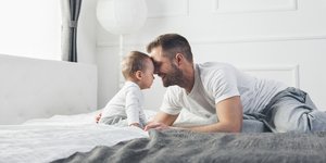 Μπαμπάς με μωρό στο κρεβάτι