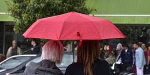 Δύο γυναίκες κάτω από κόκκινη ομπρέλα