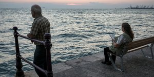 Αντρας και γυναίκα κοιτούν το ηλιοβασίλεμα