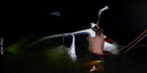 Αυτοκίνητο στα νερά της λίμνης και άνδρας σε επιχείρηση ανάσυρσης του οχήματος