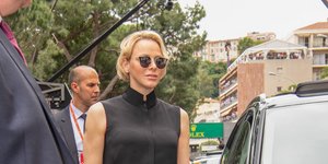 Η πριγκίπισσα Σαρλίν του Μονακό με ροζ παντελόνι, μαύρο τοπ και μαύρα γυαλιά ηλίου περπατάει στον δρόμο