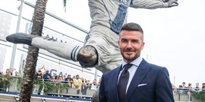 Ο Ντέιβιντ Μπεκαμ με κοστούμι μπροστά από το άγαλμα του