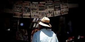 Ανδρας διαβάζει εφημερίδες σε περίπτερο