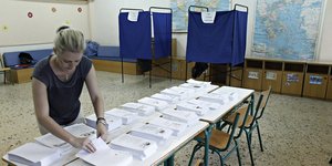 Μια εκλογική αντιπρόσωπος τακτοποιεί τα ψηφοδέλτια, σε εκλογικό κέντρο, στις εκλογές του 2015