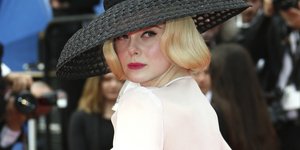 Η Ελ Φάνινγκ με καπέλο και λευκό πουκάμισο