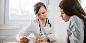 Μια γιατρός και ένα κορίτσι κοιτάζουν τις εξετάσεις σε ένα ιατρείο