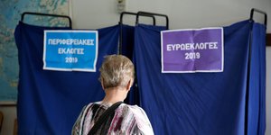 Γυναίκα περιμένει σε εκλογικό τμήμα να ψηφίσει στις ευρωεκλογές και τις αυτοδιοικητικές εκλογές