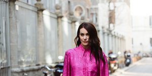 Γυναίκα με φούξια πουκάμισο και παντελόνι καμπάνα