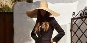 Γυναίκα με μαύρο φόρεμα και ψάθινο καπέλο