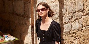 Γυναίκα με μαύρο φόρεμα και σανδάλια