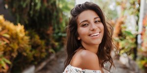 Γυναίκα με ηλιοκαμένη επιδερμίδα χαμογελά 