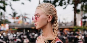 Ξανθιά γυναίκα με πλεξίδα και γυαλιά ηλίου