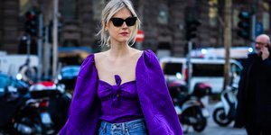 Γυναίκα με ξανθά μαλλιά, μωβ τοπ και τζιν παντελόνι 