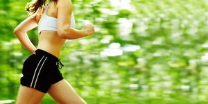Γυναίκα με αθλητικά ρούχα τρέχει στο δάσος