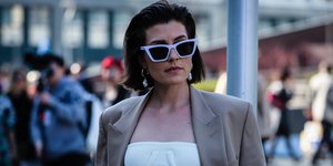 Γυναίκα με cropped top και γυαλιά ηλίου ποζάρει