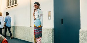 Γυναίκα στο δρόμο φορά γυαλιά και κρατά τσάντα