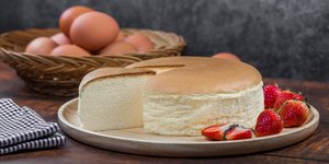 Ιαπωνικό τσιζκέικ με φράουλες και ένα μπολ αυγά στο τραπέζι