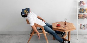 Κουρασμένος άντρας με ένα βιβλίο στο κεφάλι